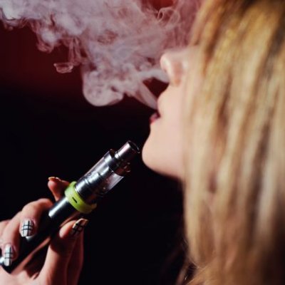 A close up of a woman vaping